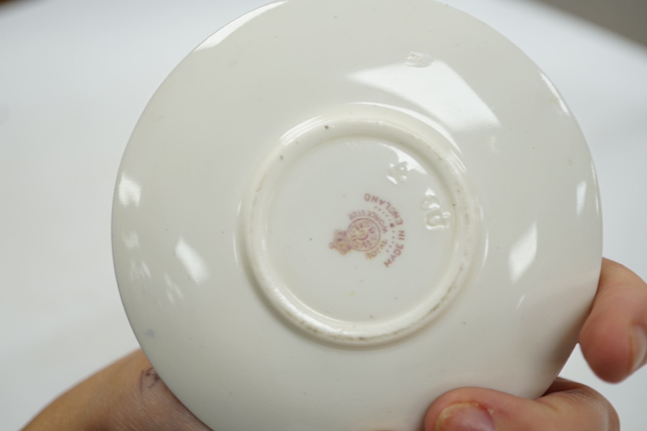 A Royal Worcester cup and saucer, painted by Harry Davis with figures in a landscape, saucer 9.5cm diameter. Condition - good